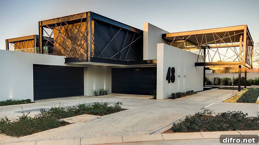 Large cantilevered boxes enclosed by black steel bars shape the South African house