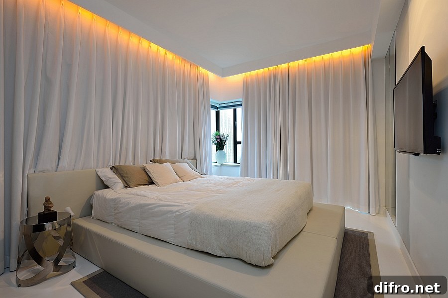 Long, white drapes turn the bedroom into a serene sanctuary