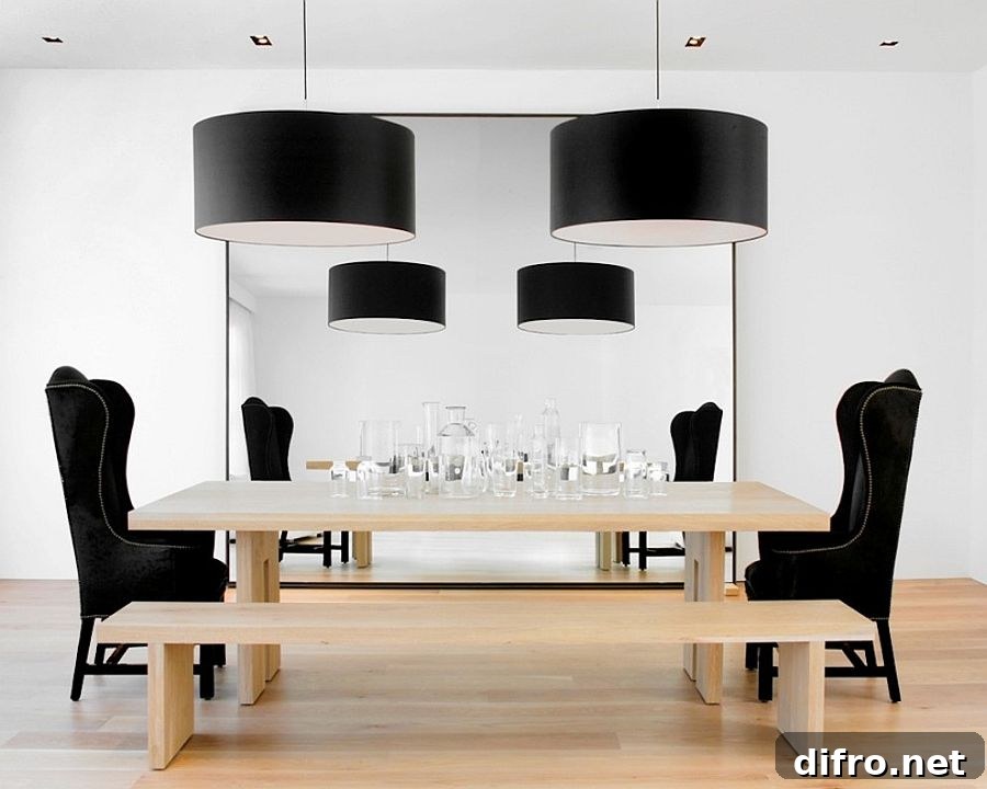 Large black drum pendants add drama to the chic dining room [Design: Nicole Hollis / Ben Mayorga Photography]