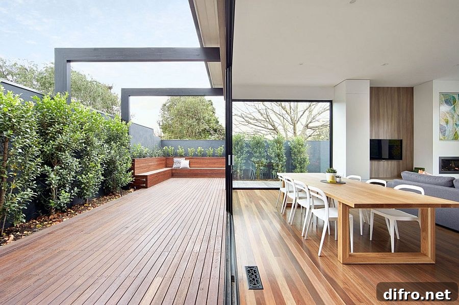 Sliding glass doors connect the new living area with the wooden deck outside