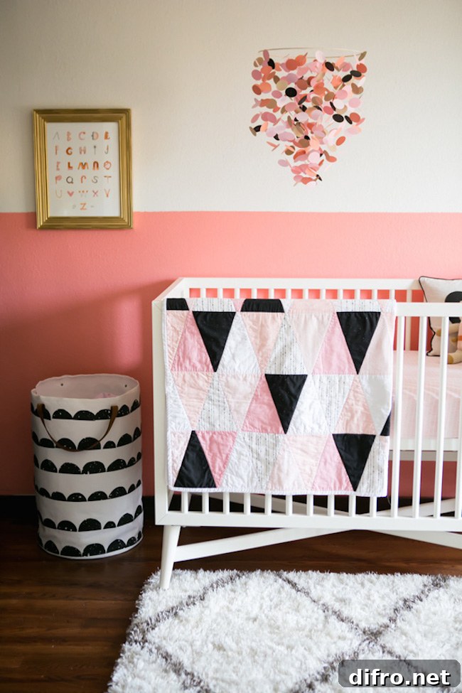 A half painted pink nursery paired with geometric crib bedding