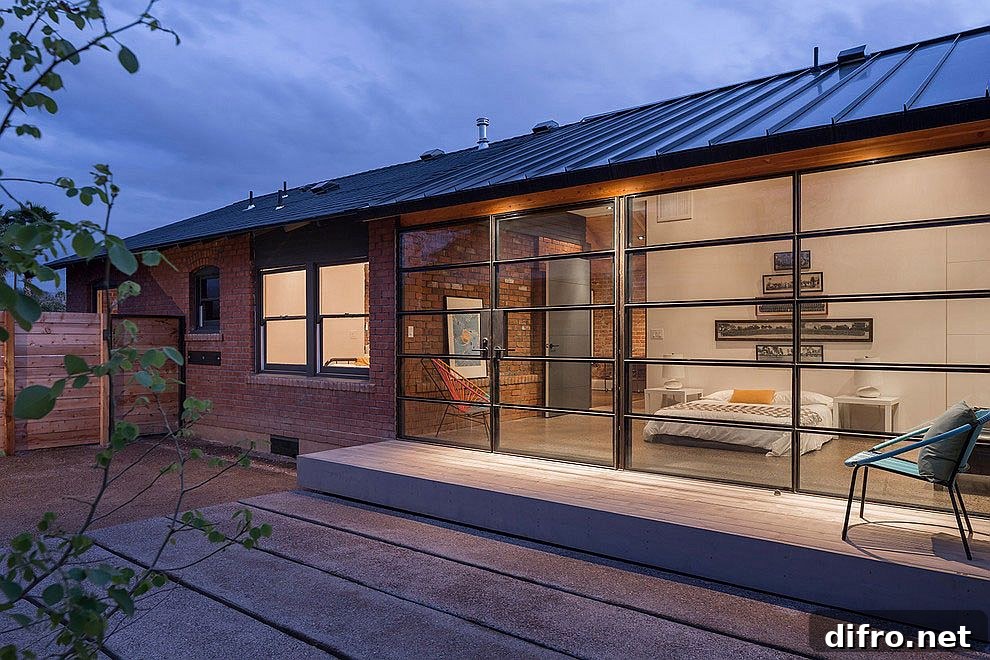 Contemporary glass and steel extension sits next to old brick, Carriage House in Phoenix