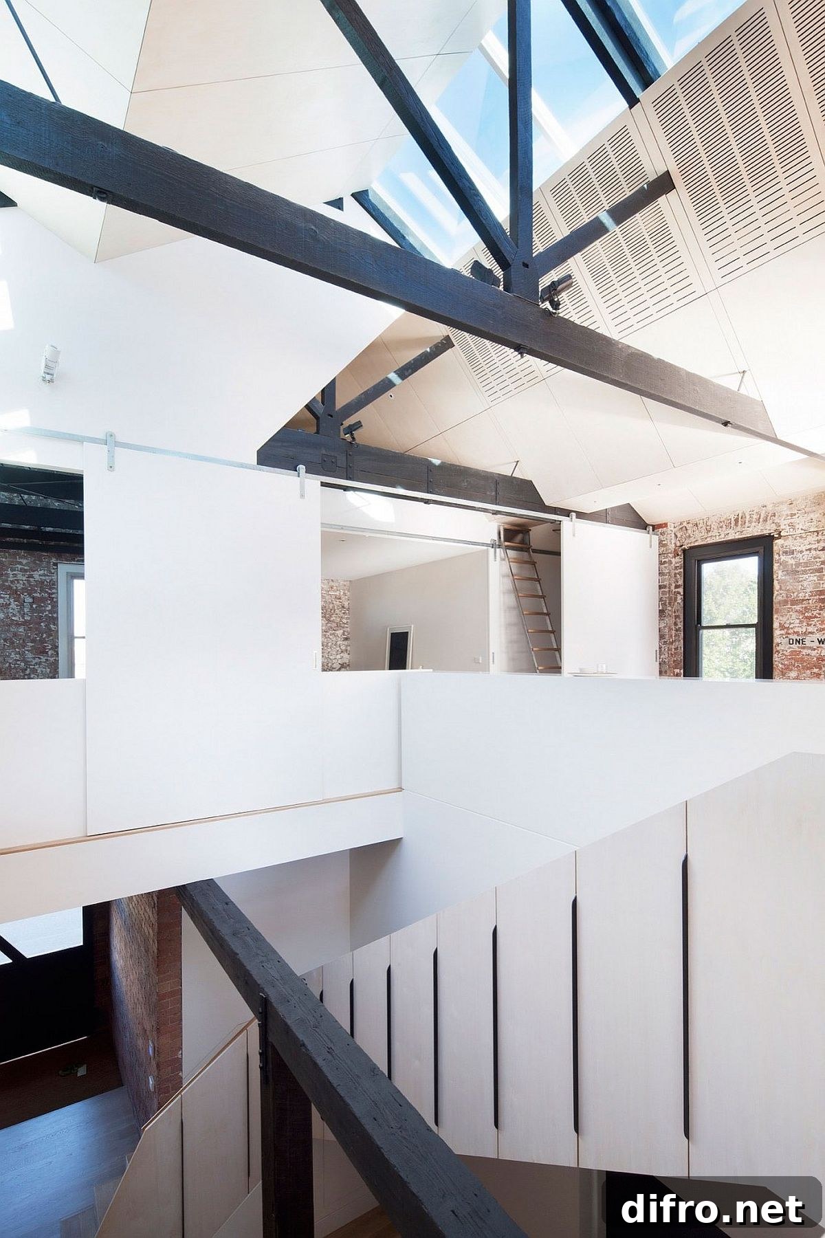 Original roof trusses and modern ceiling meet inside the converted warehouse residence