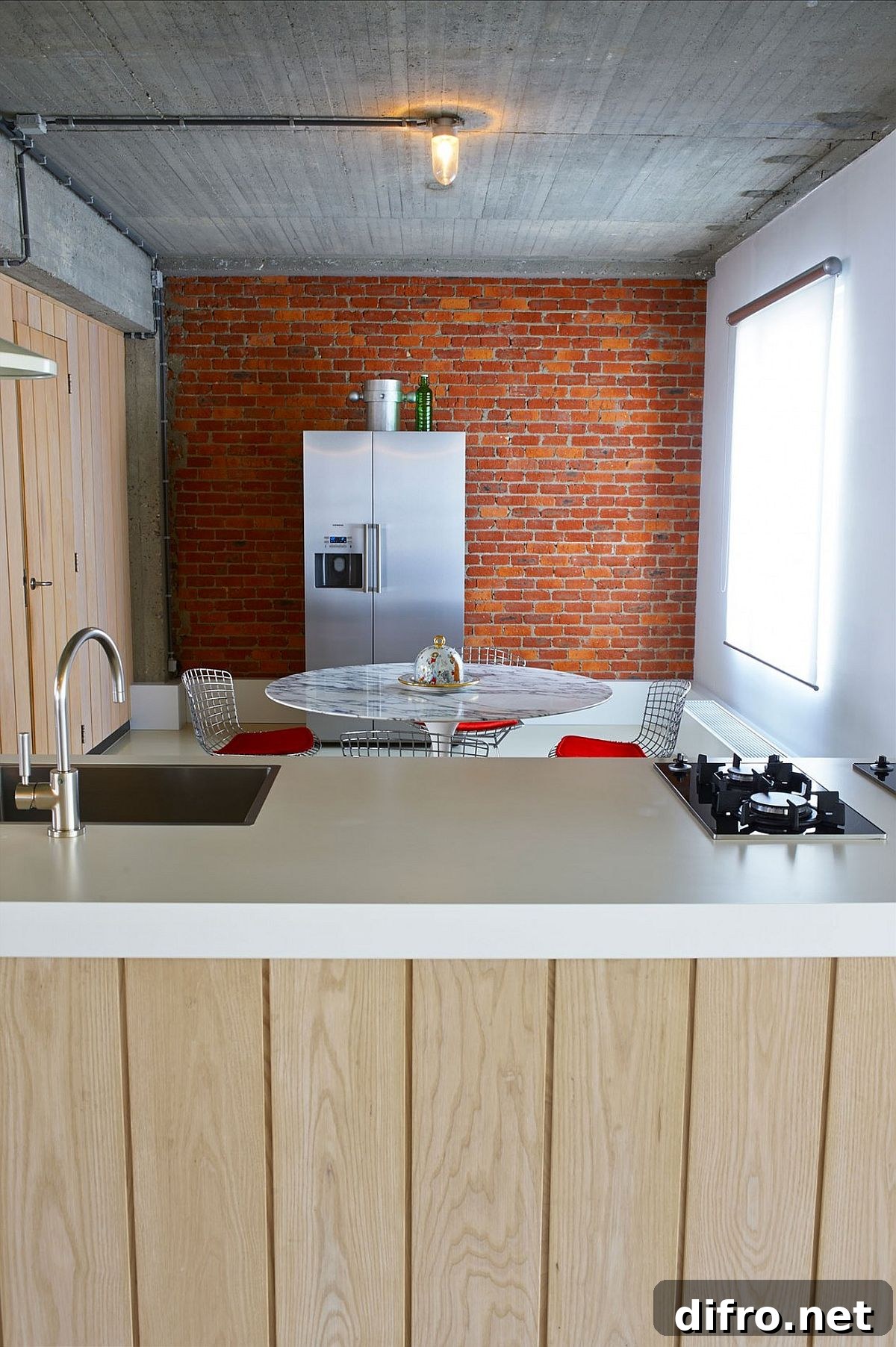 Brick wall in the backdrop of kitchen and dining room with Saarinen Tulip table