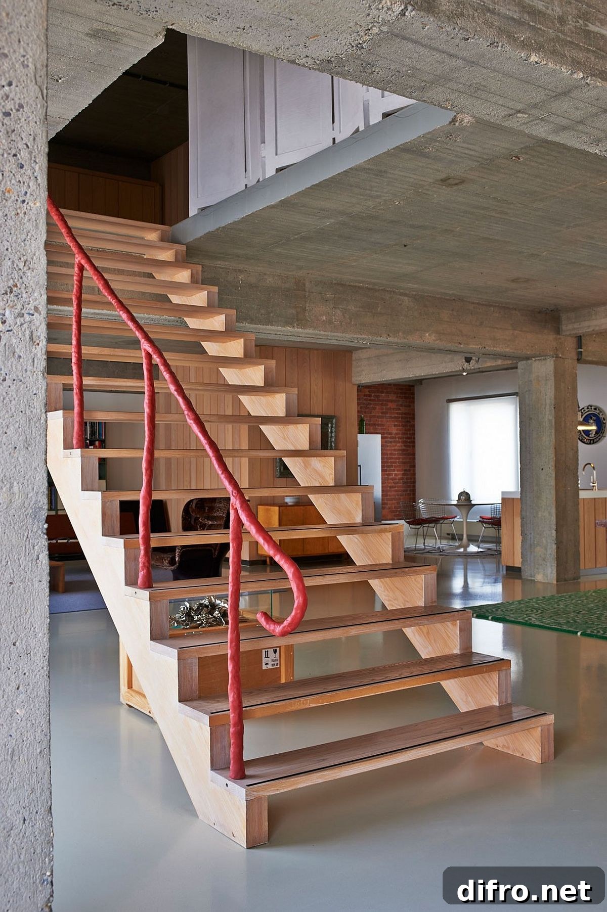 Striking wooden staircase with unqiue, colorful railing connects the two loft levels