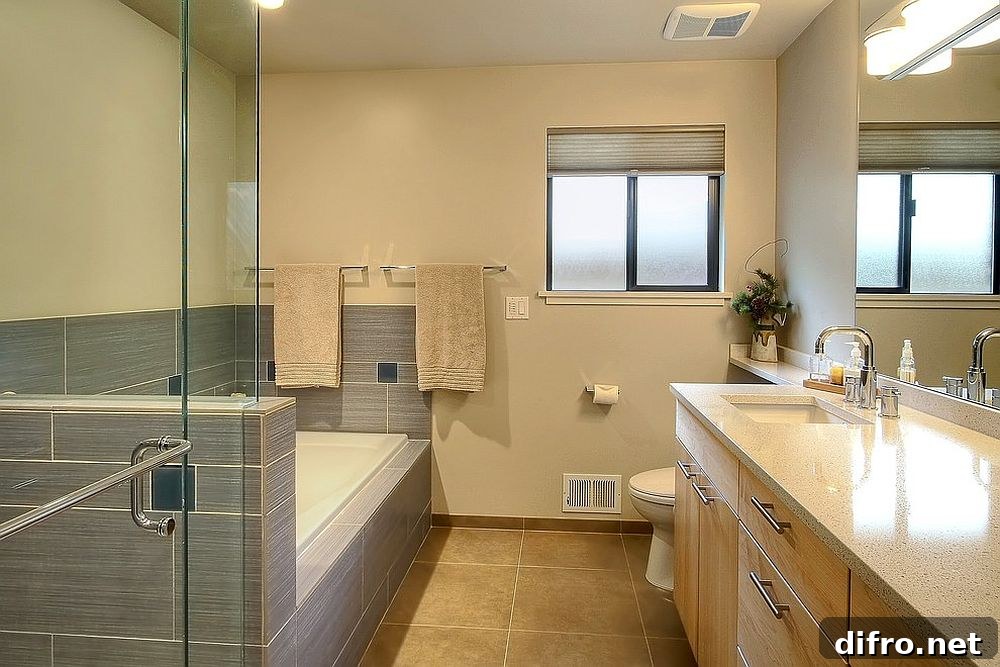 Maple cabinetry adds to the yellow and gray color scheme of the bathroom [Design: Logan’s Hammer Building & Renovation]
