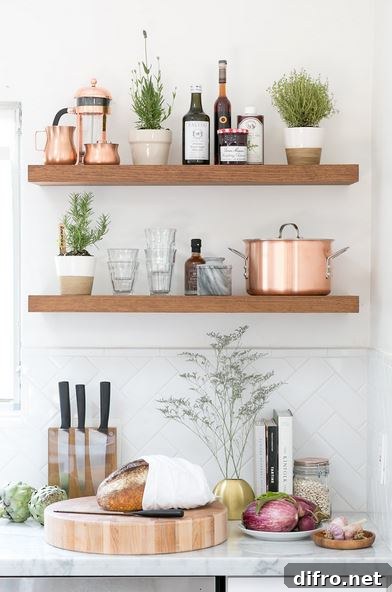 Floating Shelf Ideas to Style Your Living Room 9 Rustic kitchen with floating shelves that stocks glassware, pots, and jam.