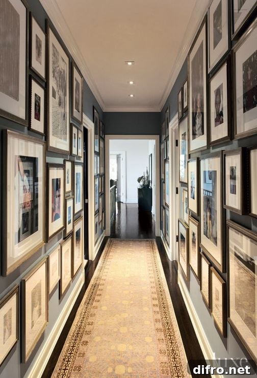 Hallway gallery with dark walls covered in many picture frames.