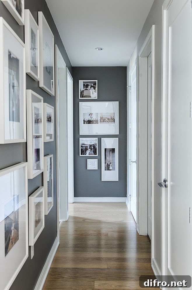 Hallway gallery with white framed pictures on the left wall and a few more on the end wall.