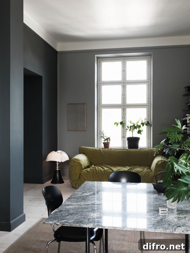 A cozy living room featuring a sleek marble table surrounded by two elegant chairs. The room exudes a warm ambiance with its tasteful decor and inviting atmosphere.