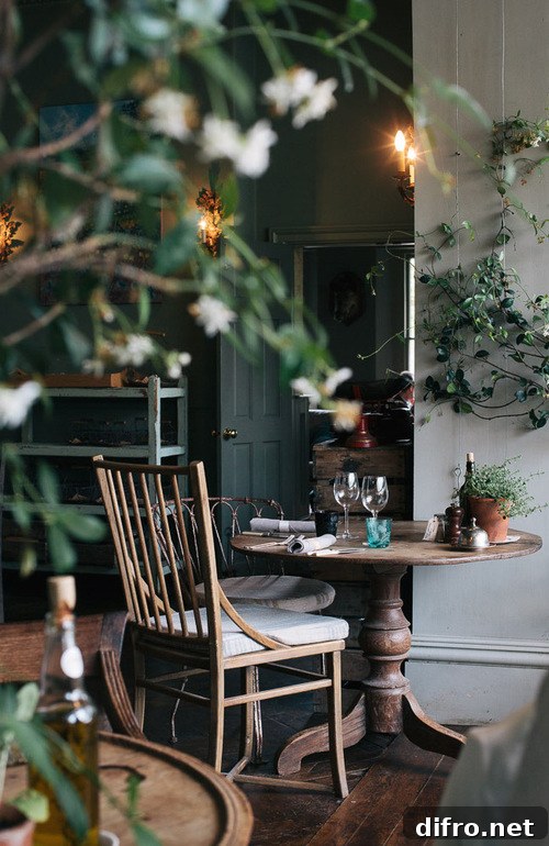 A table sits in the center of the image, adorned with two chairs near each other surrounded by greenery.