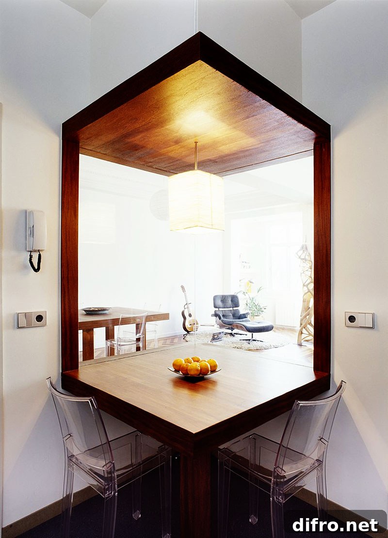 A wooden table with a colorful bowl of fresh fruit in the center is surrounded by two transparent chairs.