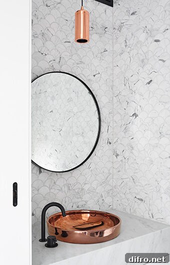 A luxurious bathroom featuring marble-like walls and a copper sink.