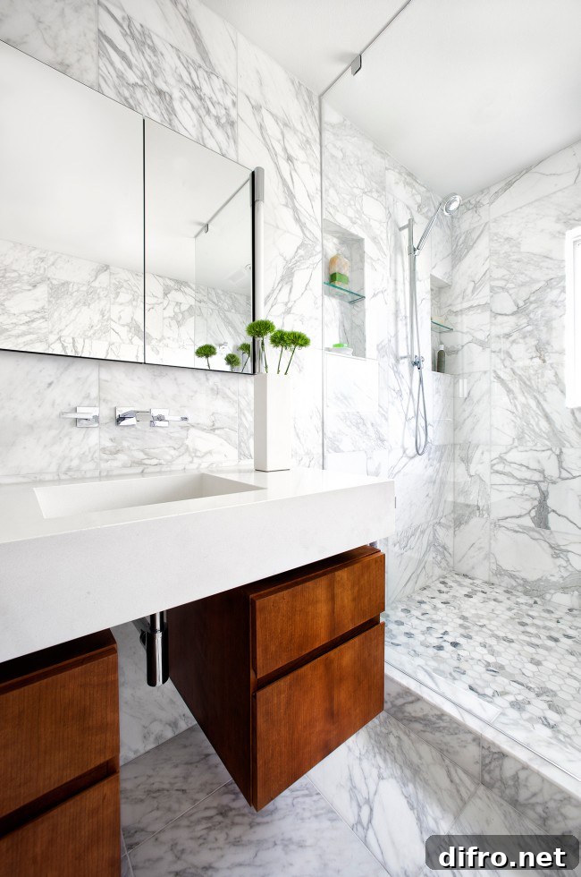 A luxurious bathroom featuring elegant marble walls and flooring with wood cabinets.