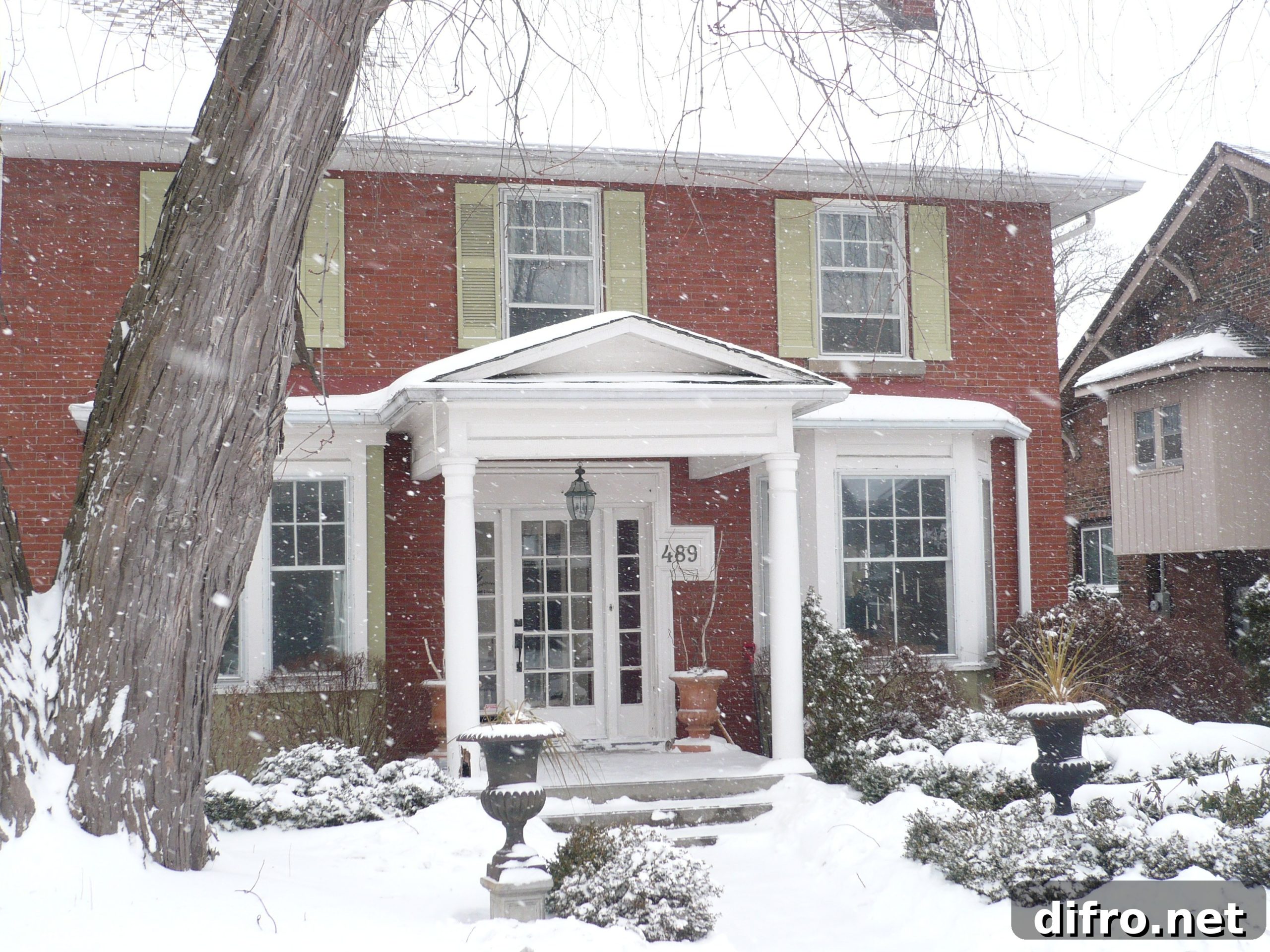 Red brick house covered in snow.