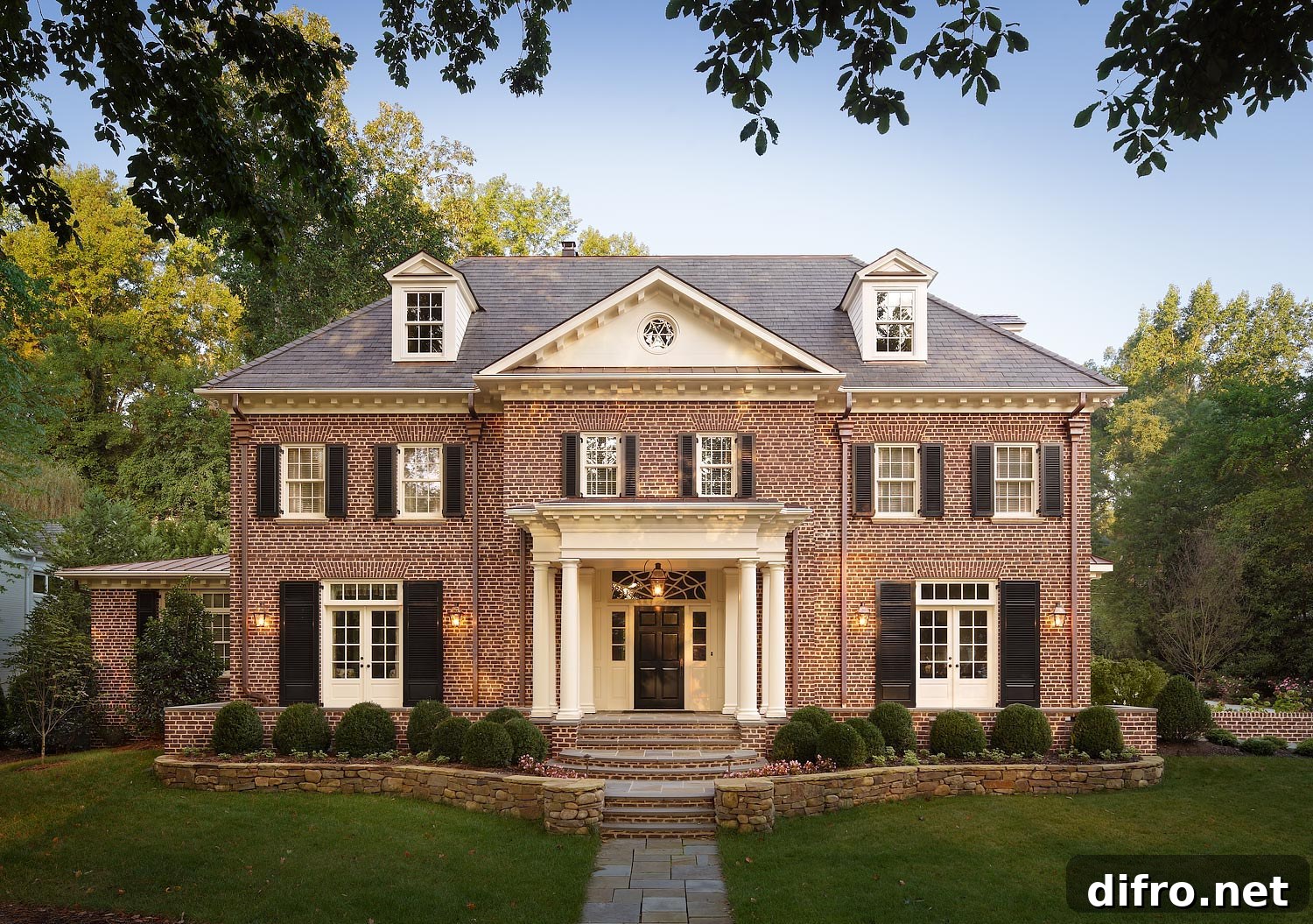 Red brick home with white columns and dormer windows