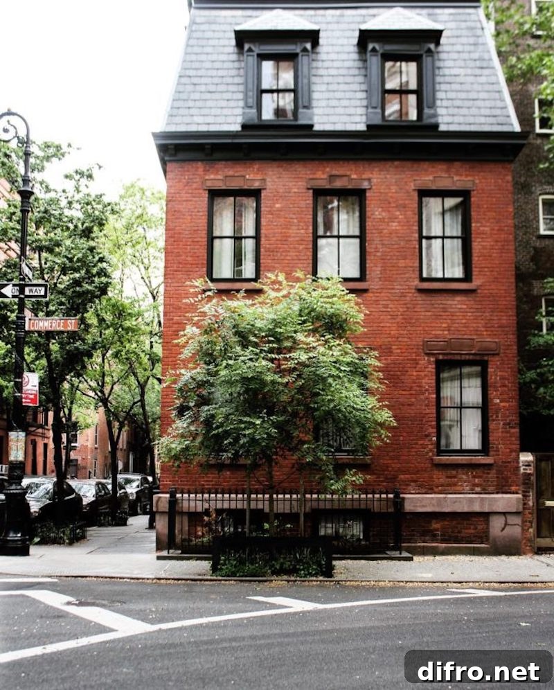 Red brick house with a medium-sized tree and black finishes.