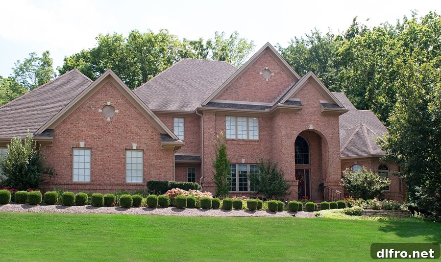 Feded red brick house with green front grass and multiple roof peaks.