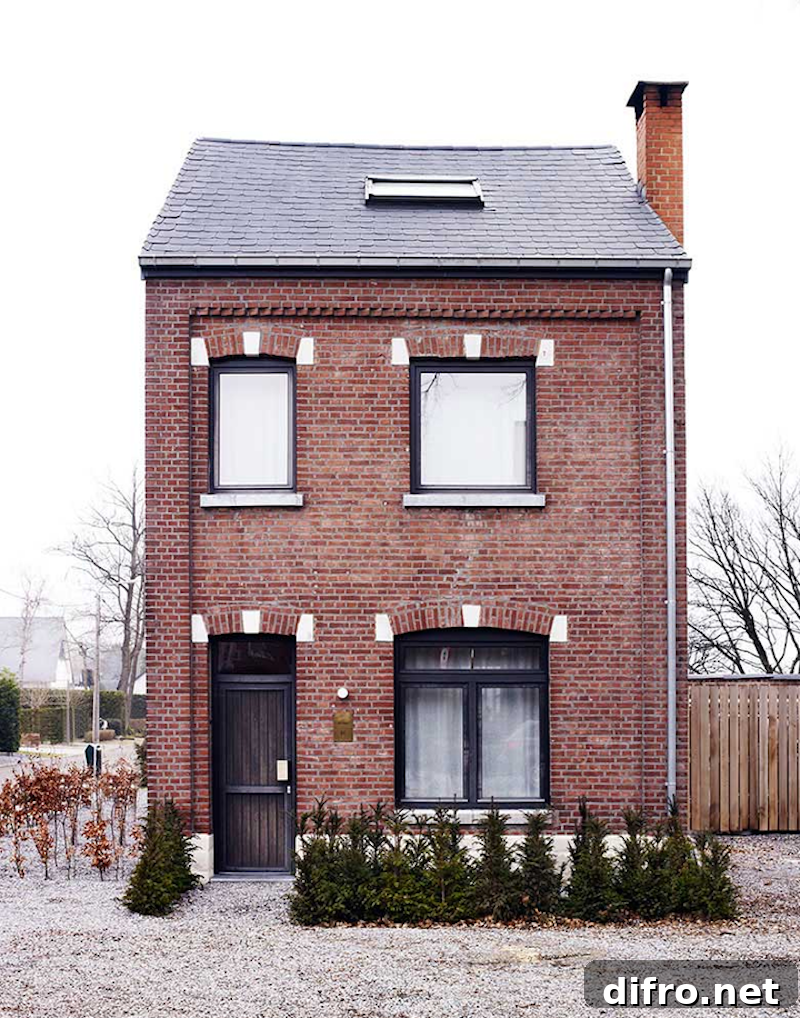 Red brick house with black window trim and chimney.