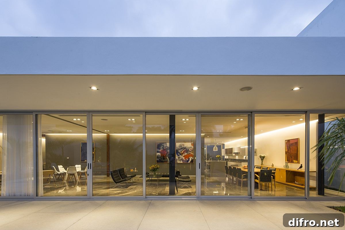 Sliding glass doors connect the interior with the pool space outside