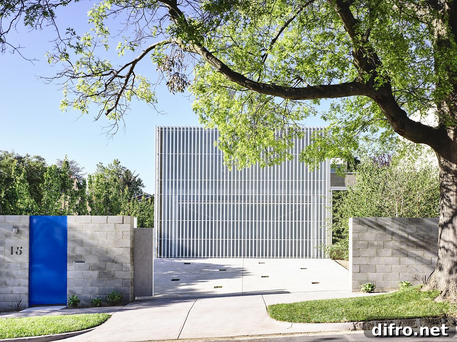 Street facade with white metal grille and blue gate