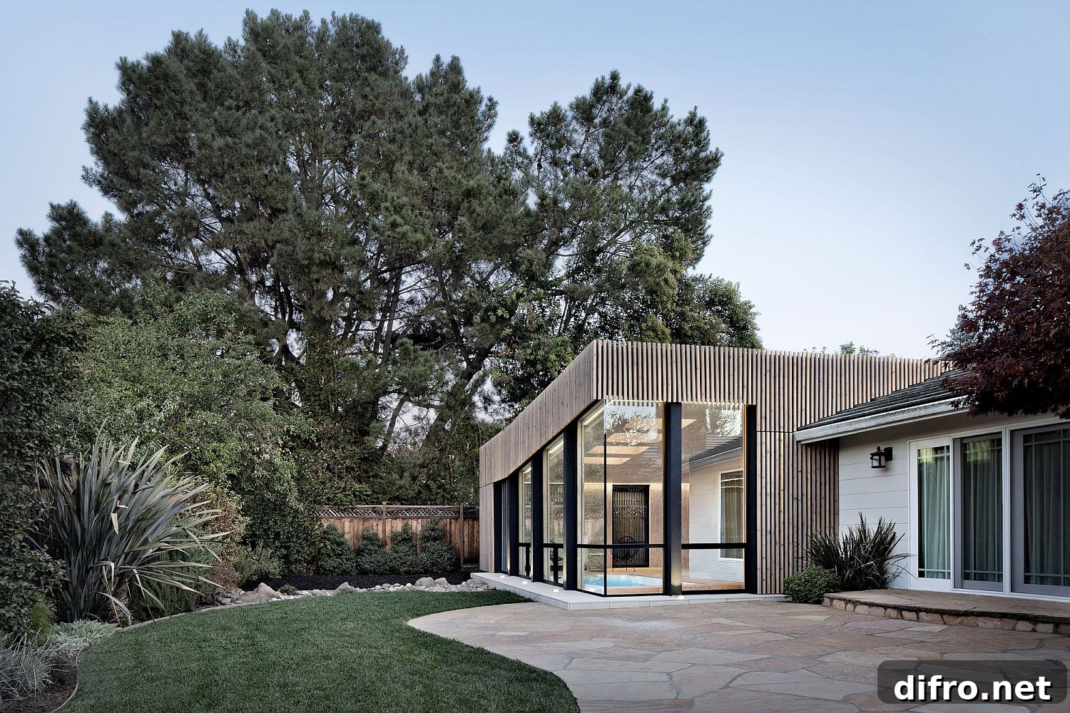 Contemporary pool house sits next to older home