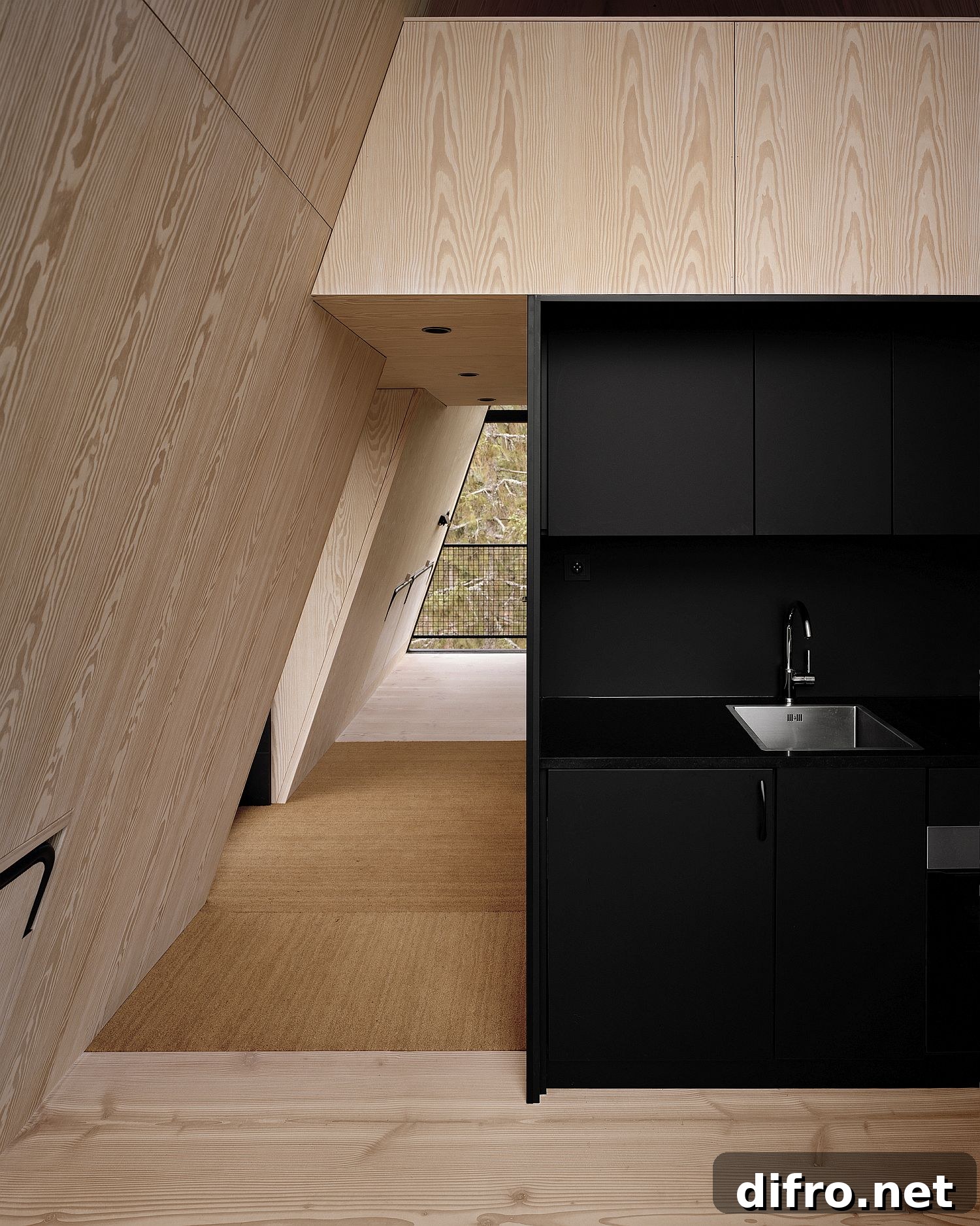 Compact black and wood kitchen inside the cabin