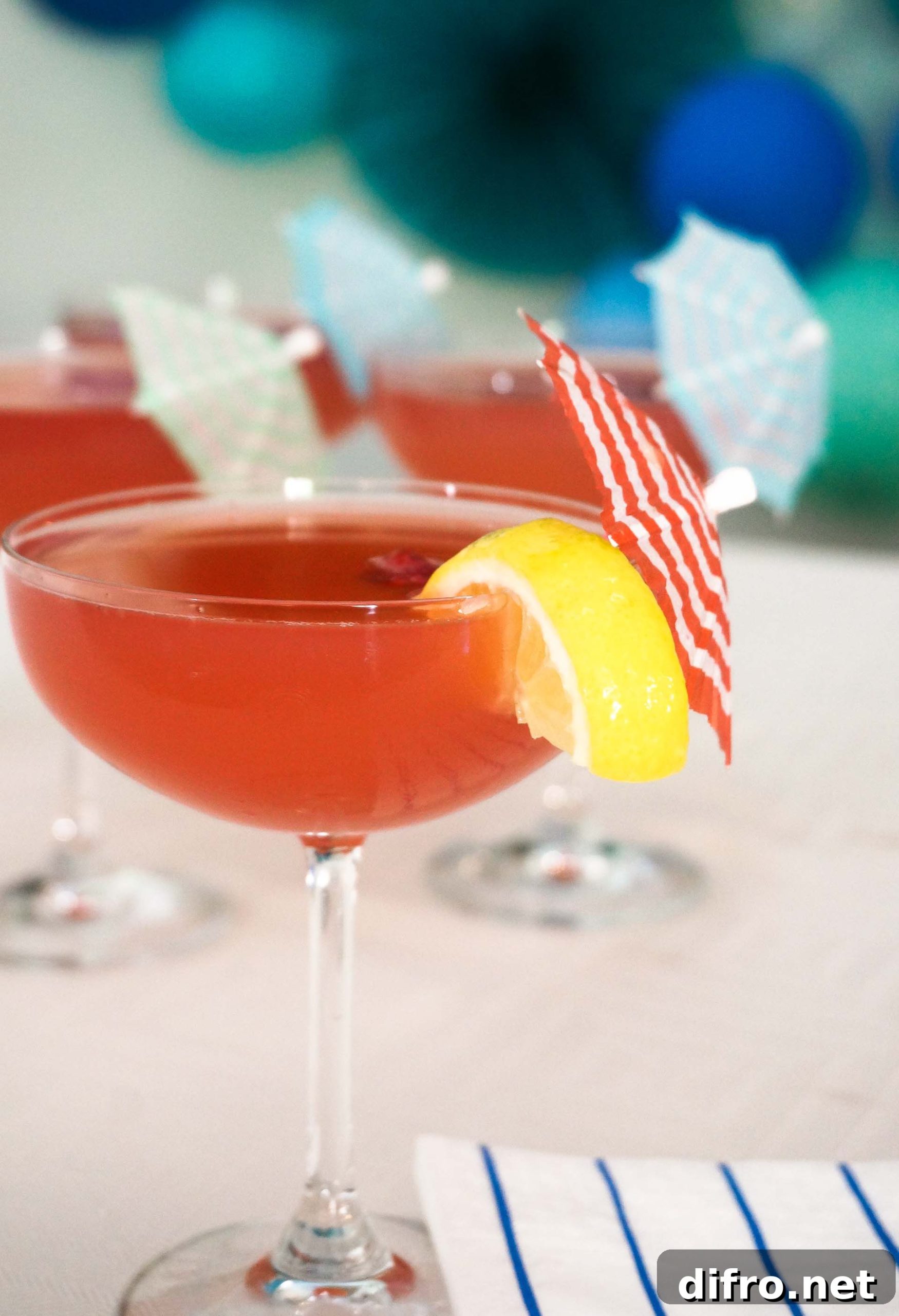 Pitcher of blood orange mimosa with lemon garnish