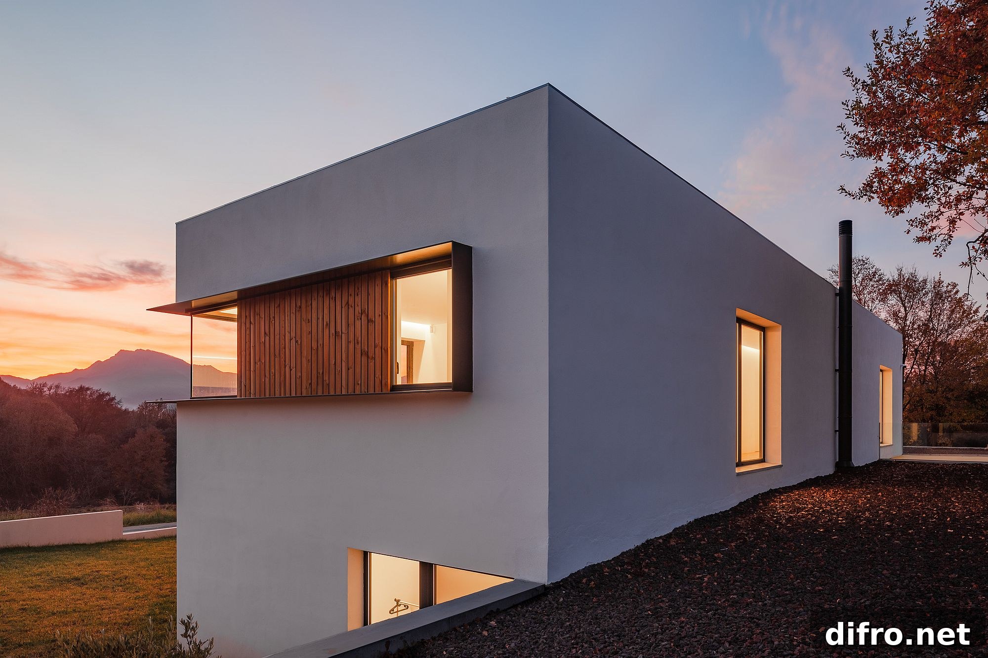 Sloped lot with contemporary home in white that has a private street facade