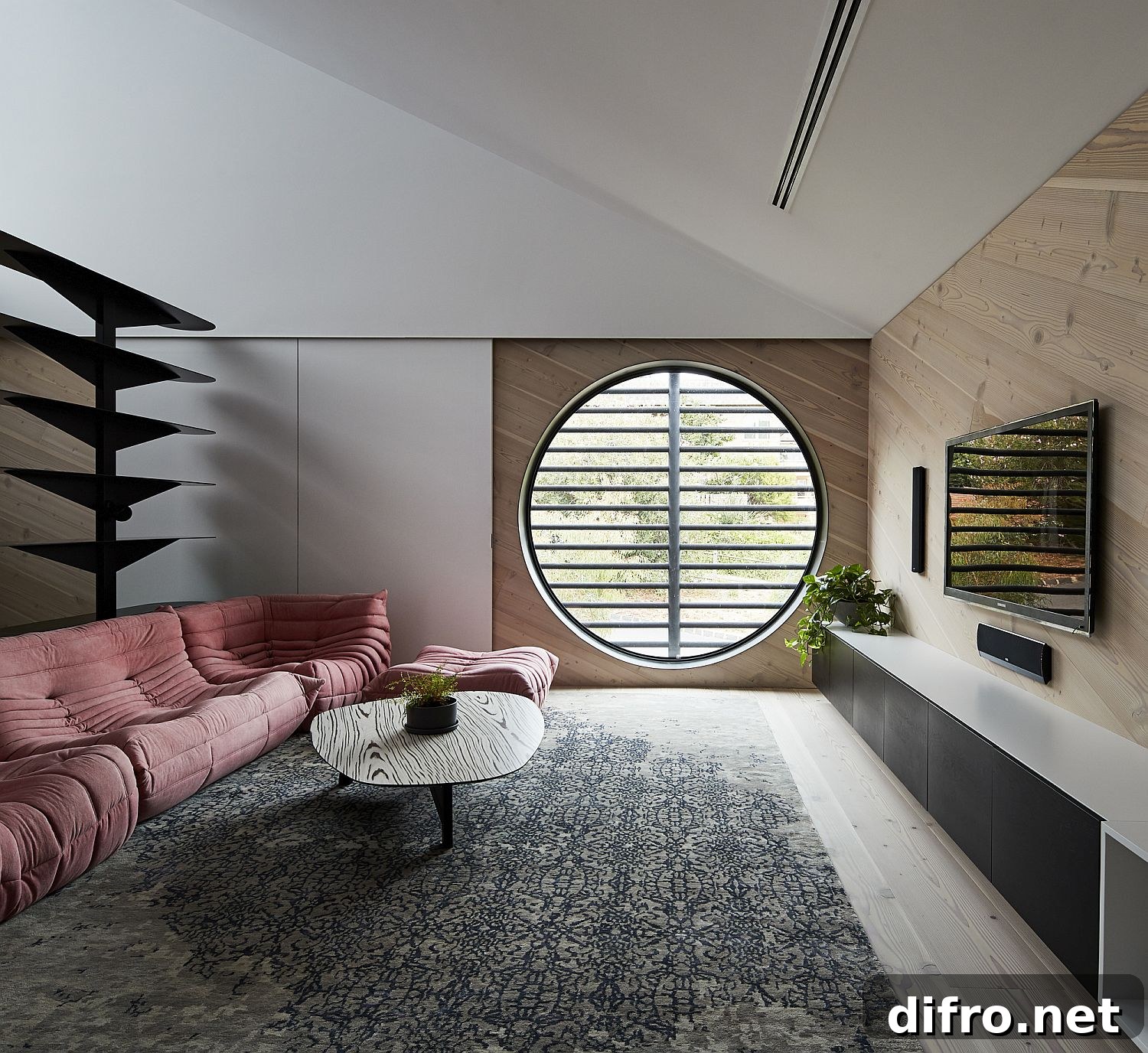 Round window and plush pink sofa