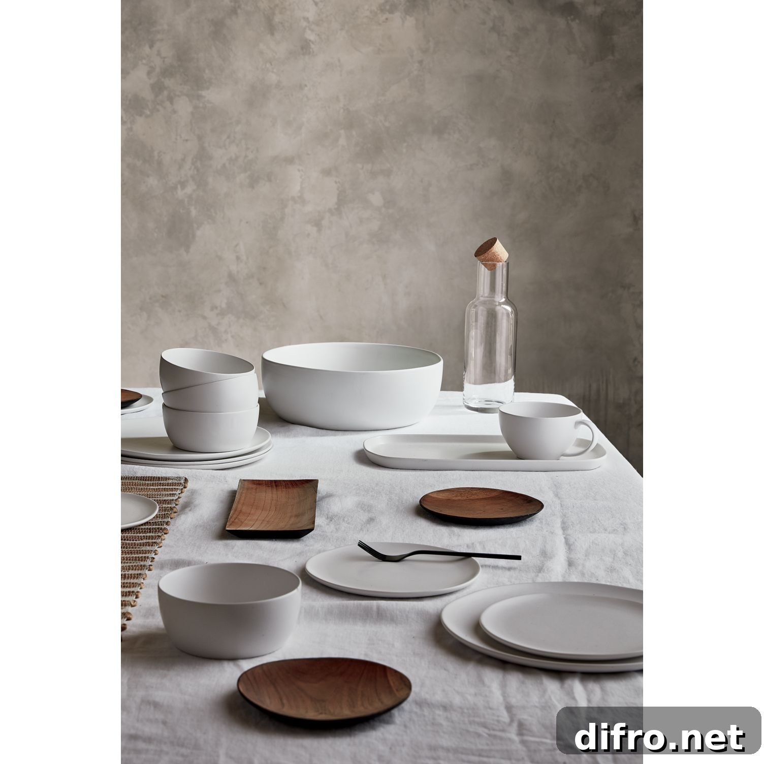 Assorted tabletop pieces in neutral tones on a table runner