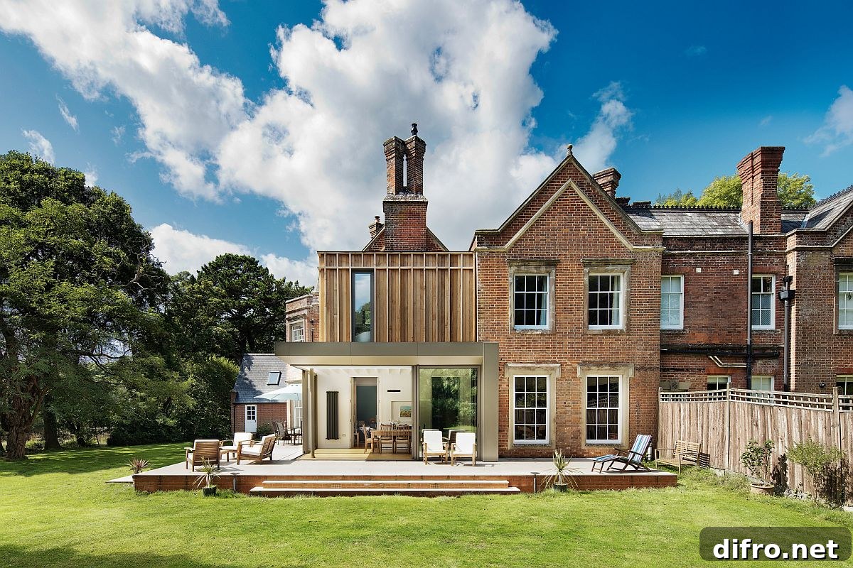 Rear extension of the house with a large wooden deck and dining room next to it