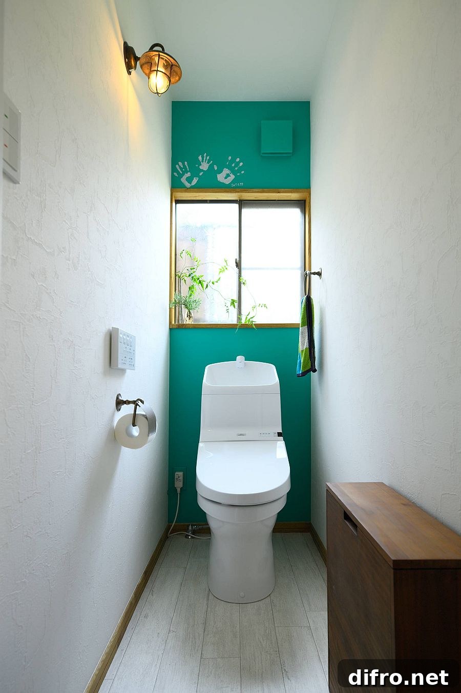 Narrow powder room with dark green accent wall