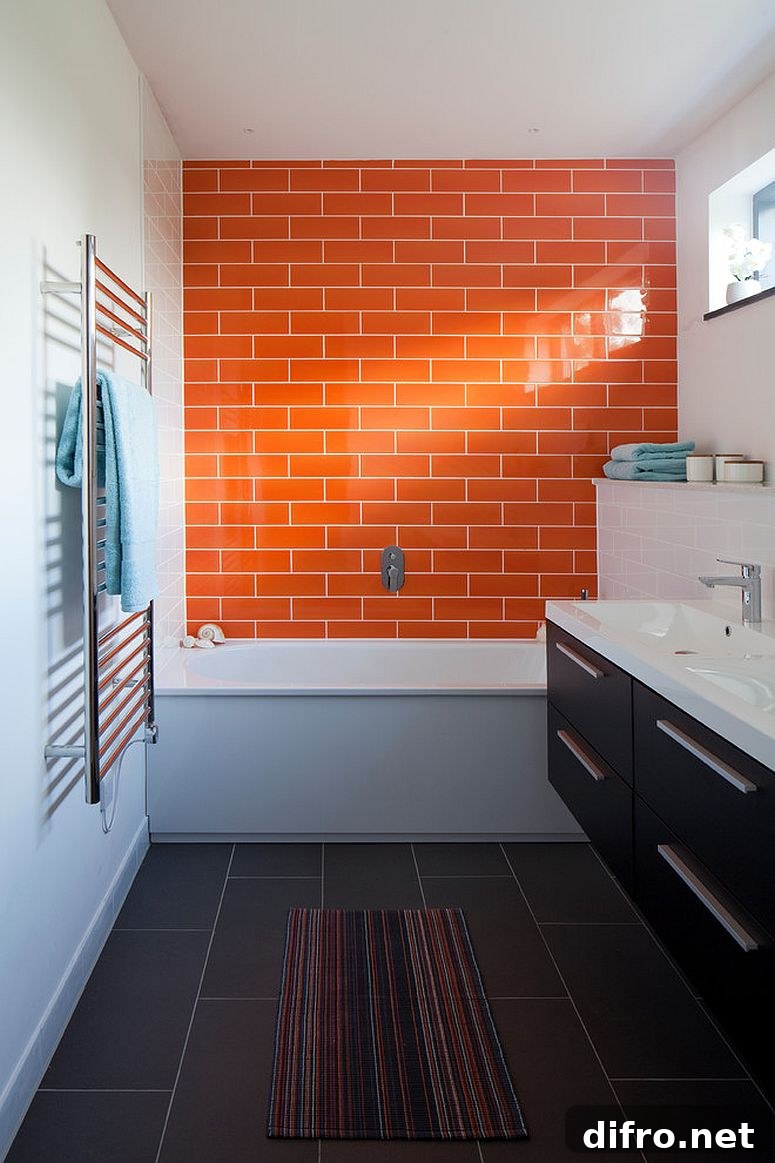 Orange tiled accent wall in a narrow modern bathroom