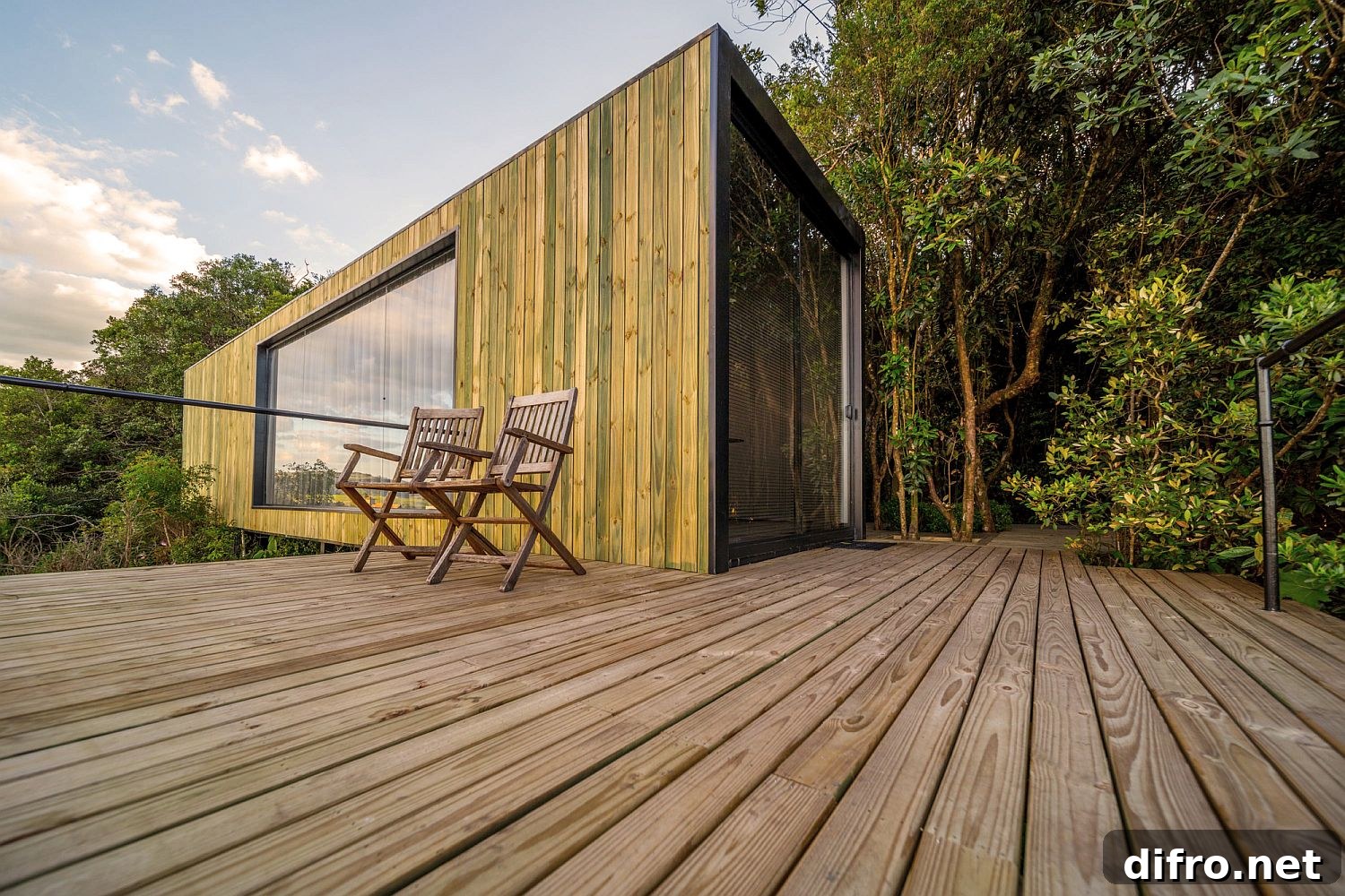 Deck and outdoors of the cabin draped in wood and surrounded by greenery