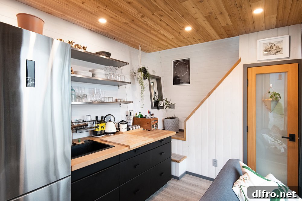 Wood and white kitchen with dark workstation in tiny cabin