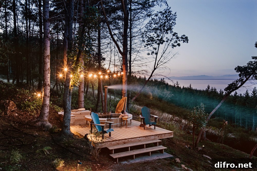 Deck with string lights and hot tub overlooking views