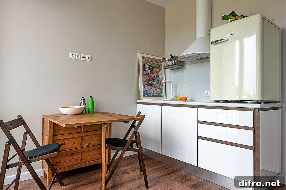 Folding table with twin chairs forming a smart breakfast zone in a small kitchen