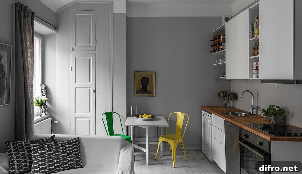 Monochromatic kitchen with colorful chairs in the breakfast zone