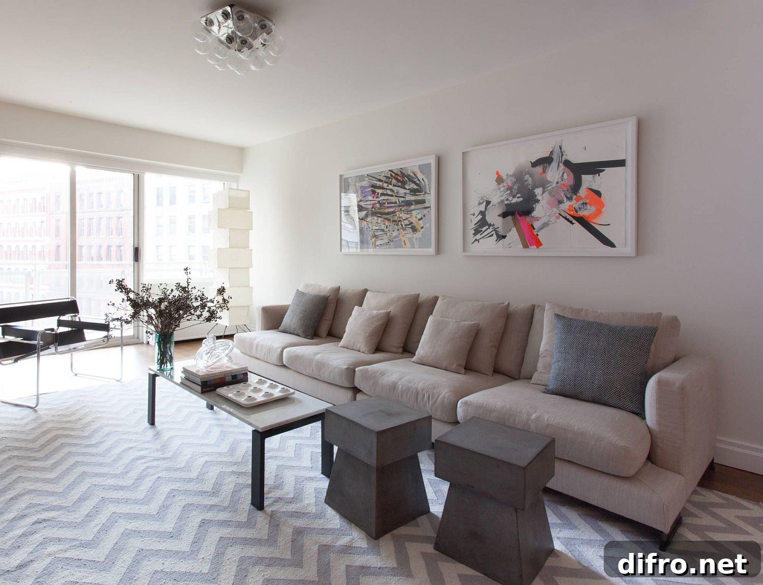 Minimal white living room with chevron flooring and a dash of color in the wall art