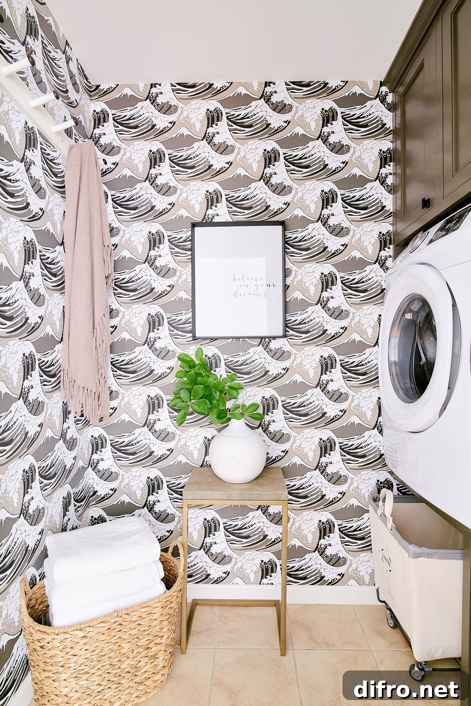 small laundry nook with wallpaper featuring brown, white, and pink ocean waves