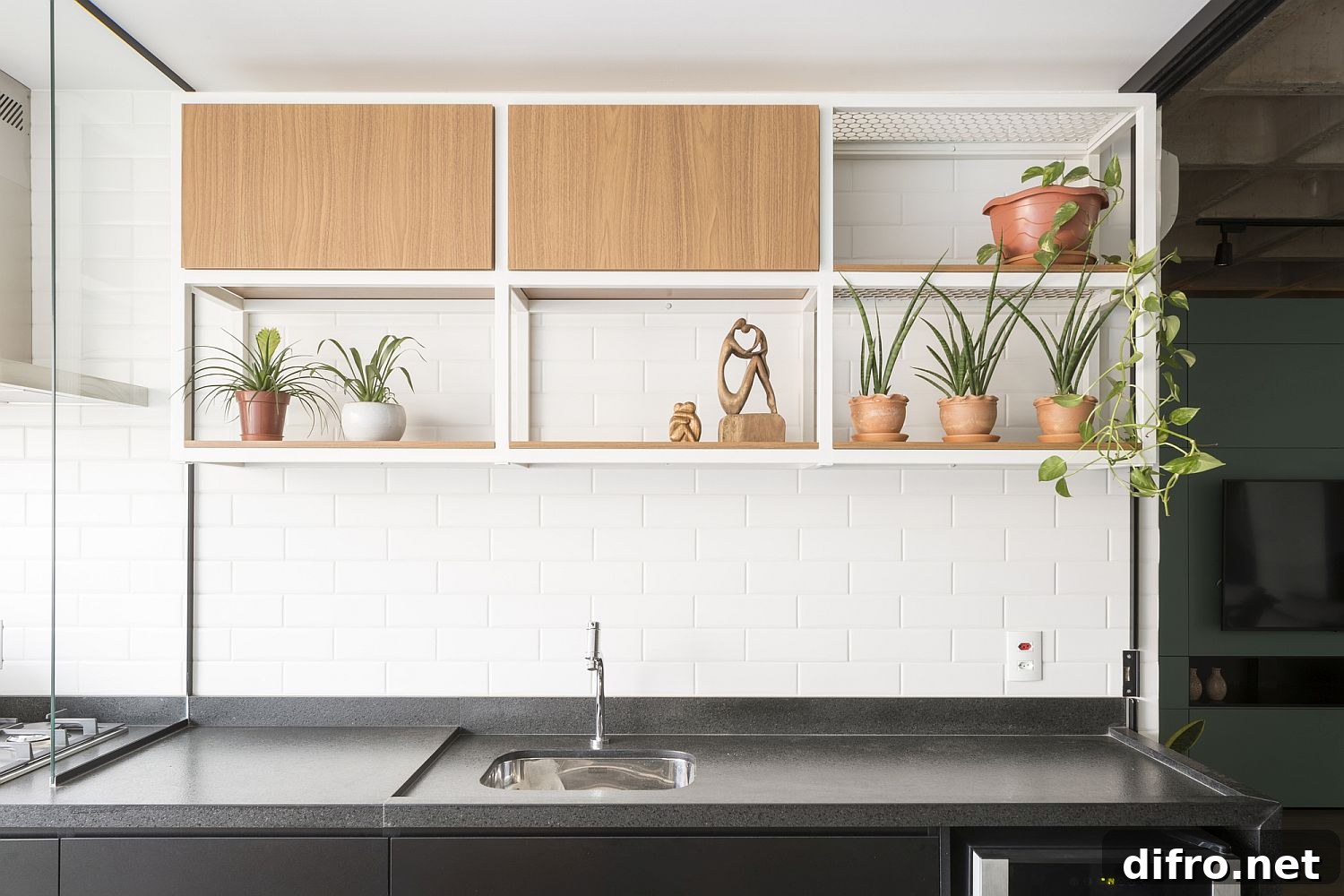 Kitchen wall in white tiles with small shelving and plants