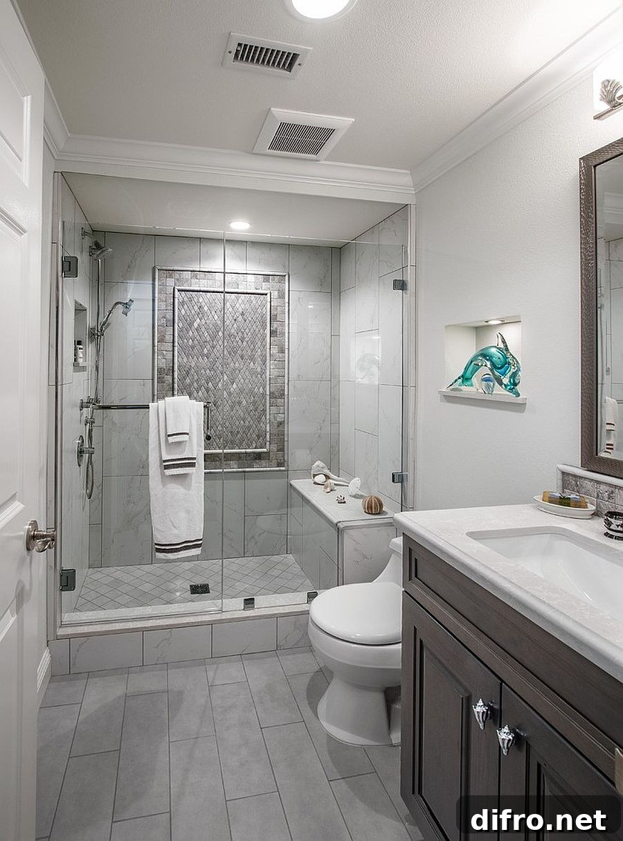 Modern bathroom with gray floor tiles and glass shower.