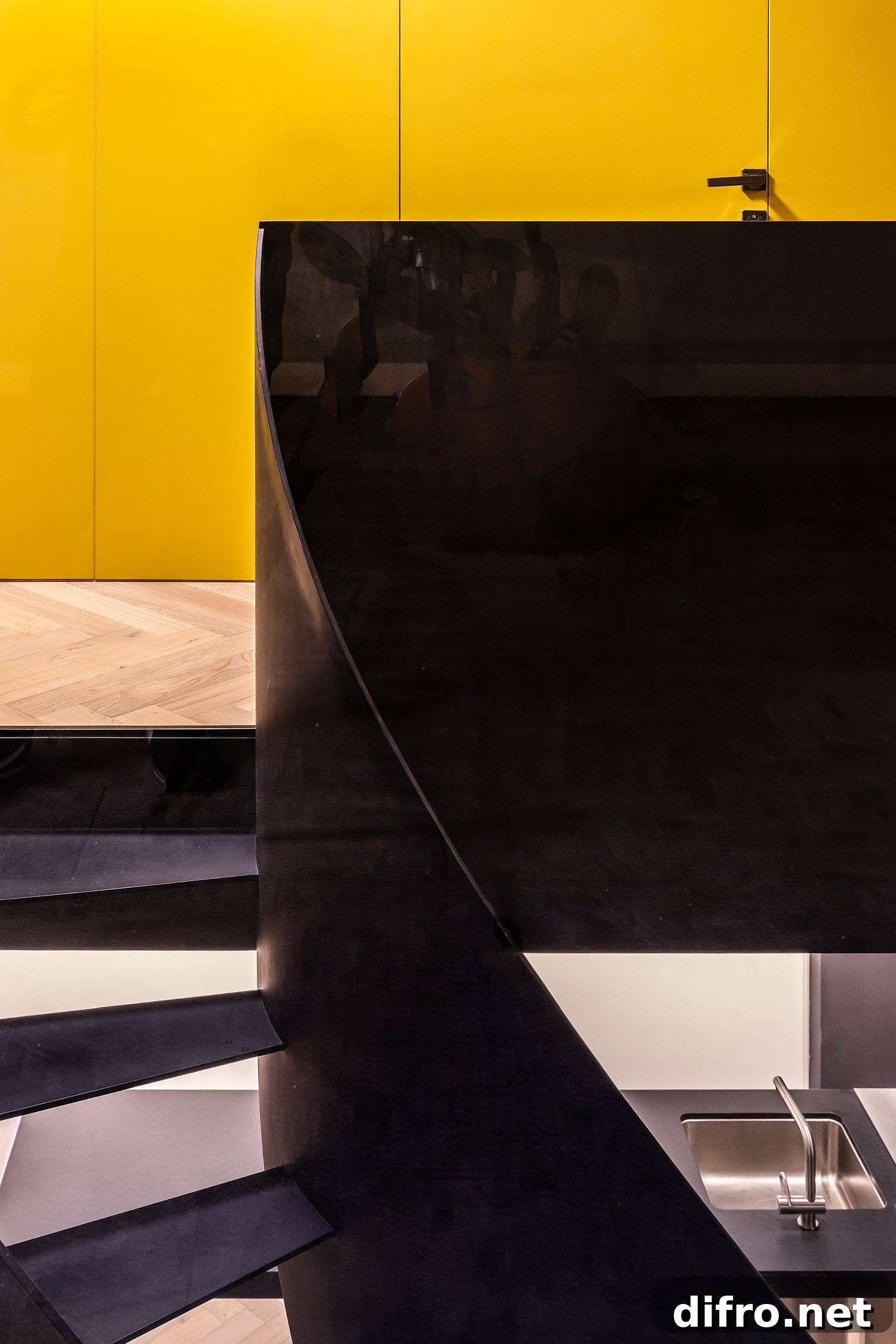 Black staircase stands in contrast to the yellow wooden backdrop
