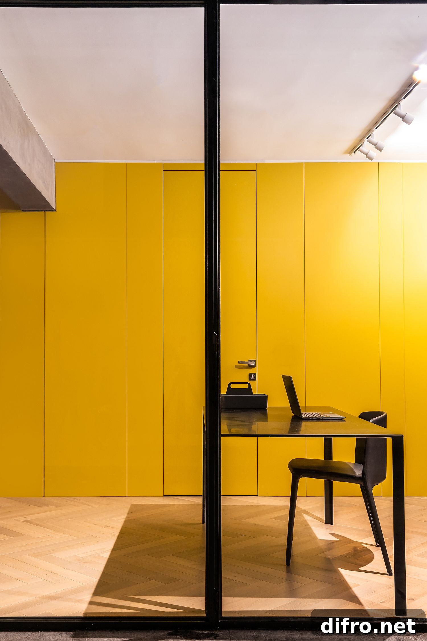 Custom mustard yellow wall in wood hides bathrooms and bedrooms behind it