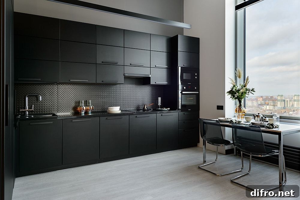 Single-wall black kitchen with adjacent dining space and large window
