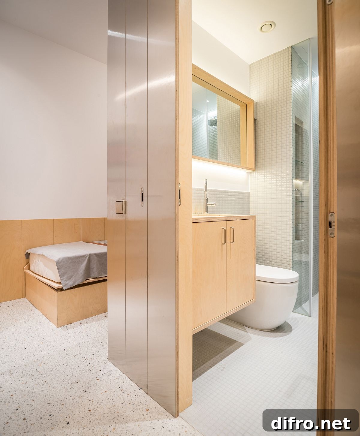 Tiny bedroom and bathroom in wood and white inside the small apartment