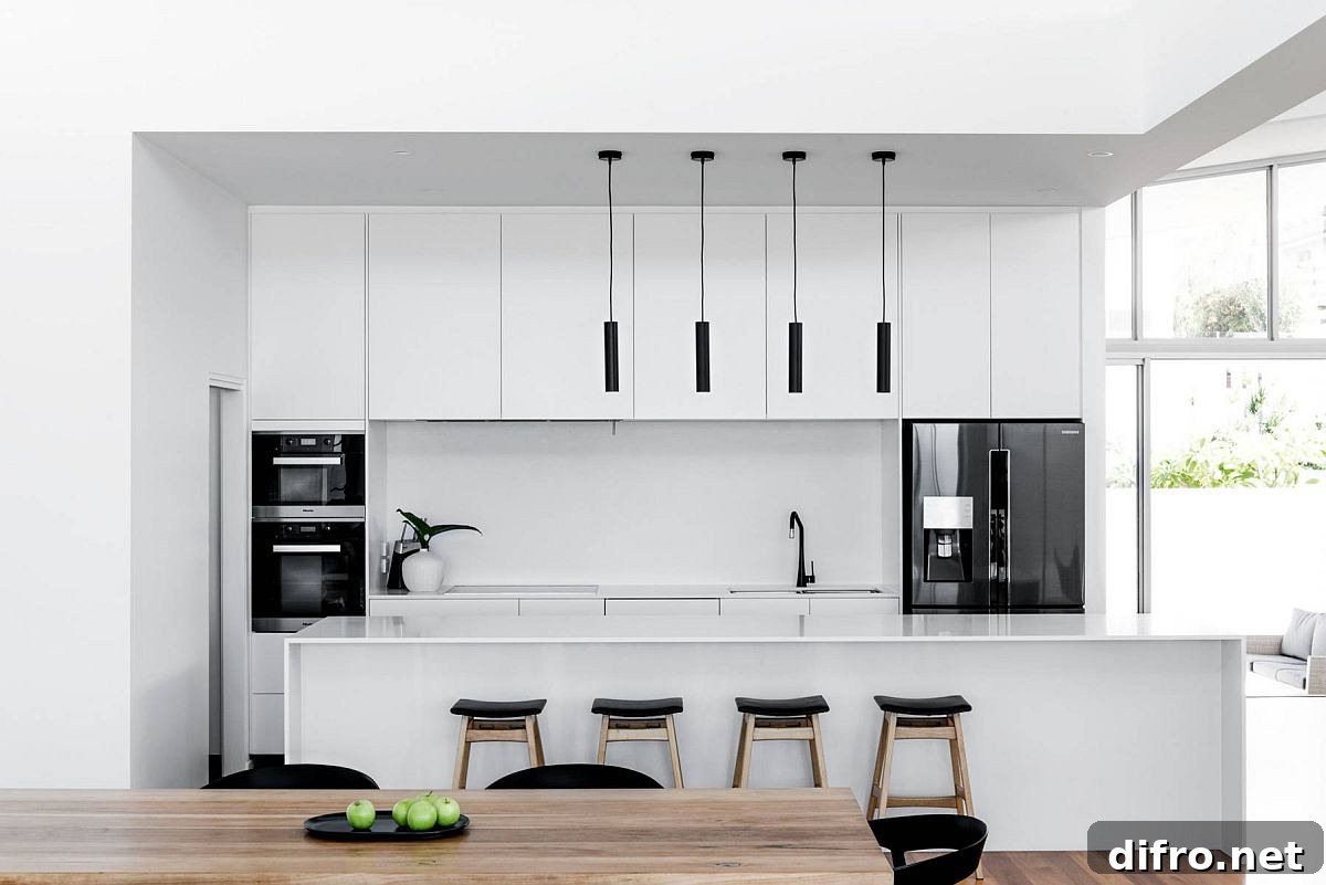 Minimal white kitchen with dark appliances