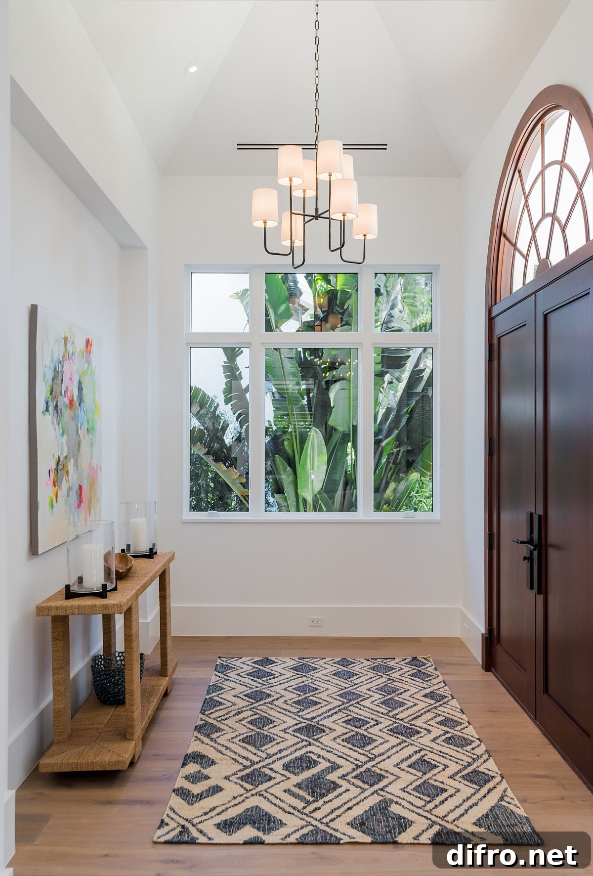 High-ceiling white entry with a wooden console table