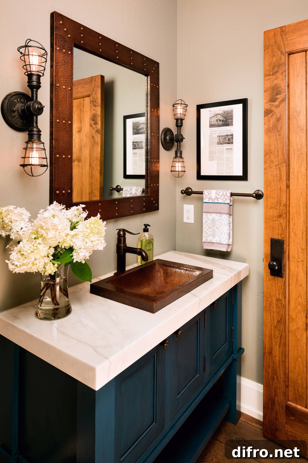 Posh blue vanity with sconce lighting in a farmhouse powder room